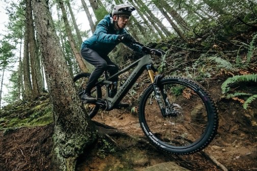 a man riding a bike down a dirt road